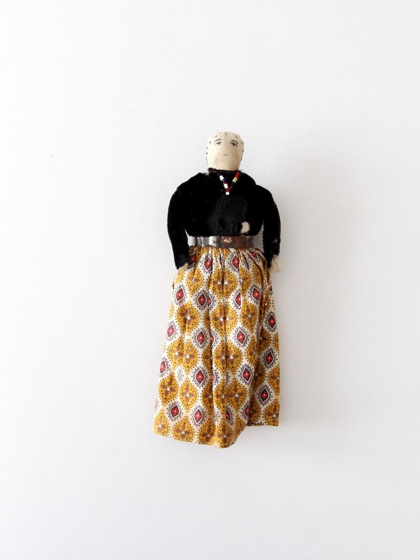 Navajo Style 7.25 Inch Cloth Doll With Beaded Jewelry And Velvet Outfit: Navajo Style 7.25 Inch Cloth Doll With Beaded Jewelry And Velvet Outfit This vintage Native American doll reflects the artistry of the Navajo tradition, featuring a painted cloth face and dressed in c