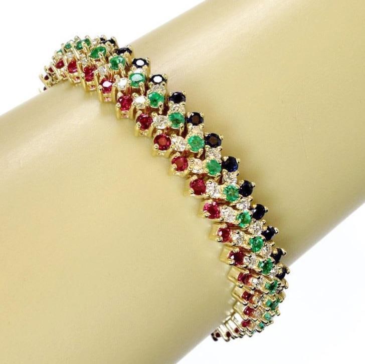 Stunning 18k Yellow Gold Flex Bracelet with Diamonds and Gemstones: Stunning 18k Yellow Gold Flex Bracelet with Diamonds and Gemstones This exquisite wide flex bracelet is crafted from 18k yellow gold with a high polished finish. It features five rows of stunning gems