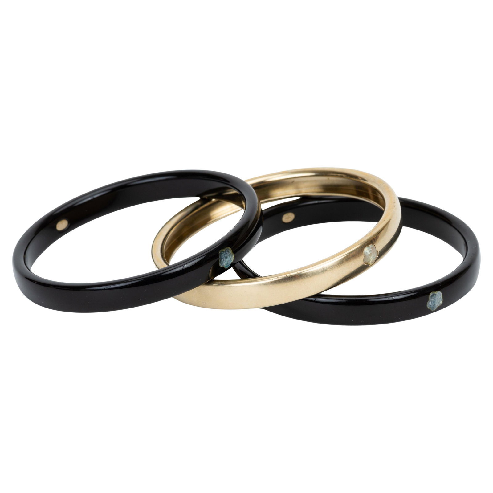 Chanel CC Logo Resin Bangle Trio: Chanel CC Logo Resin Bangle Trio This set of three Chanel bangle bracelets features two black and one gold narrow bangles crafted from resin and adorned with mother of pearl CC logos. Designed in the 