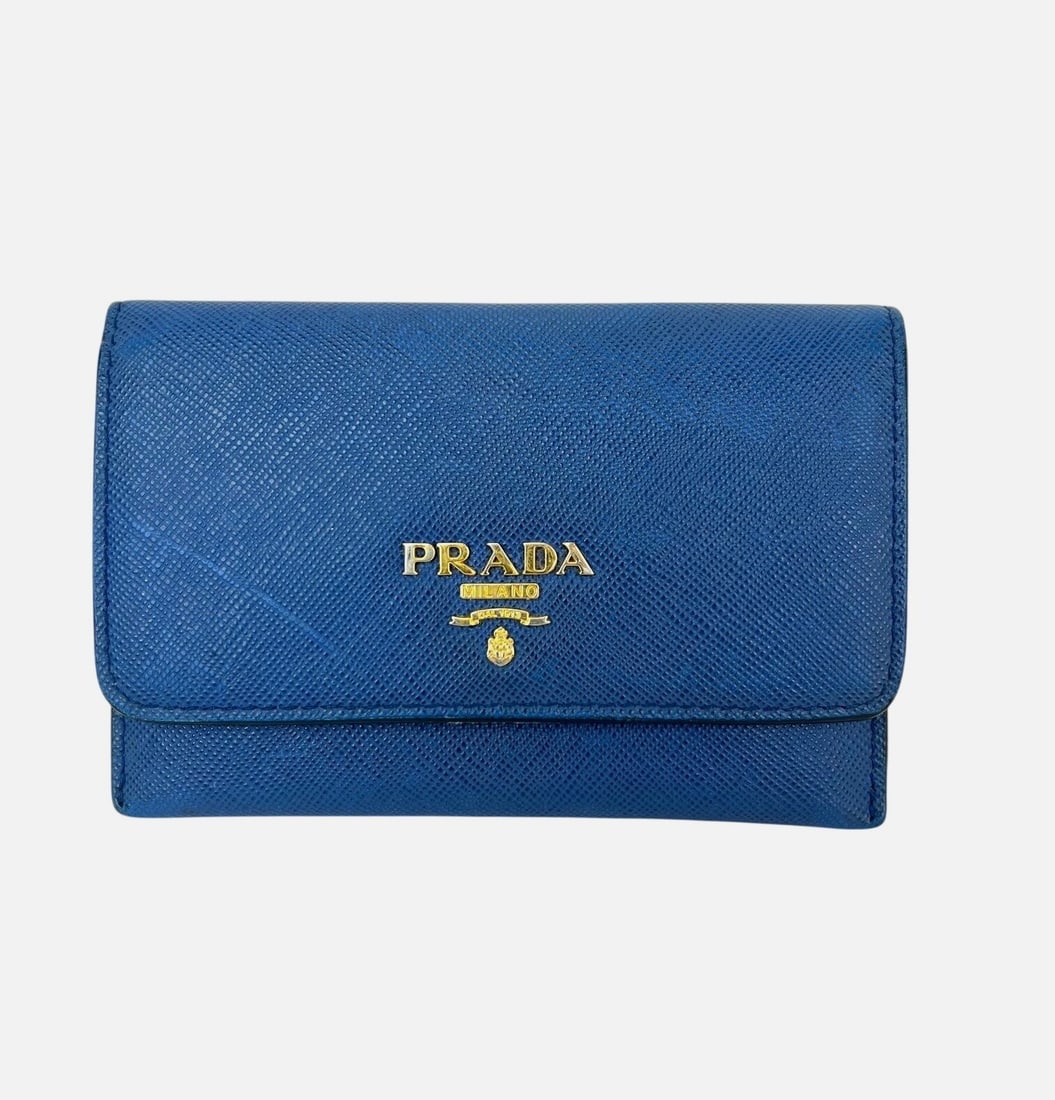 PRADA Saffiano Blue Leather Card Wallet Flap Style: PRADA Saffiano Blue Leather Card Wallet Flap Style Prada Saffiano leather card holder in blue, designed in a flap style with a solid pattern and logo accent. This pre-owned women's card wallet is made