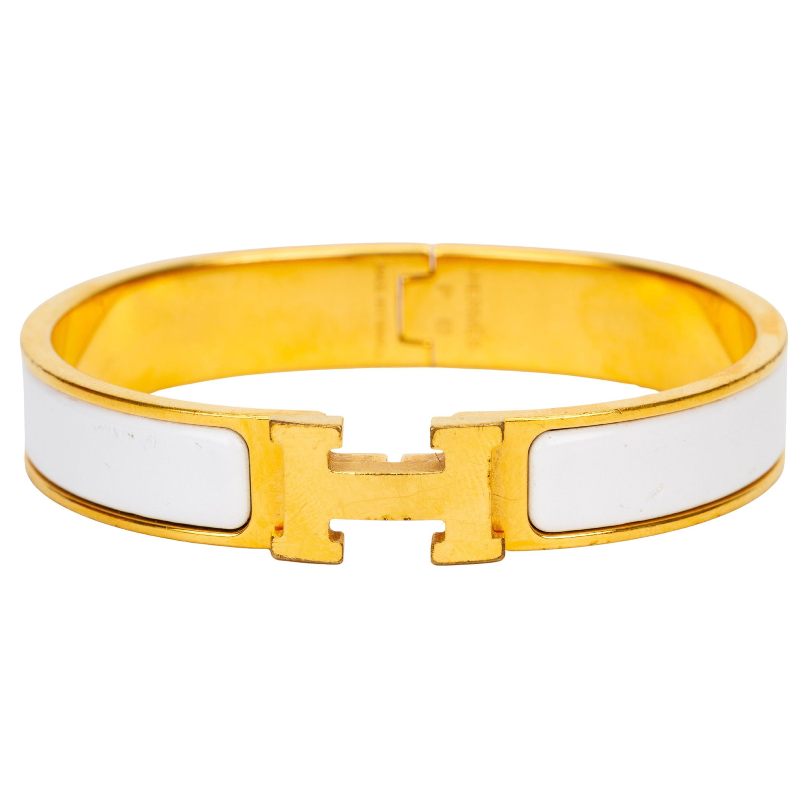 Hermes White Enamel Narrow Clic H Bracelet: Hermes White Enamel Narrow Clic H Bracelet This Hermes Clic "H" narrow bracelet features a white enamel band complemented by a gold-tone "H" clasp. Crafted in France in 2018, this elegant accessory sh