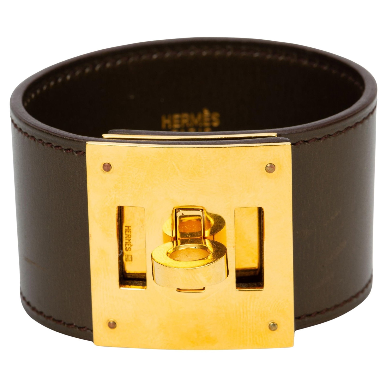 Hermes Kelly Dog Gold Tone Brown Box Calfskin Bracelet with Dust Bag: Hermes Kelly Dog Gold Tone Brown Box Calfskin Bracelet with Dust Bag Hermes Kelly Dog Bracelet crafted in Box calfskin leather, featuring a gold-tone Kelly closure. This bracelet comes with a dust bag