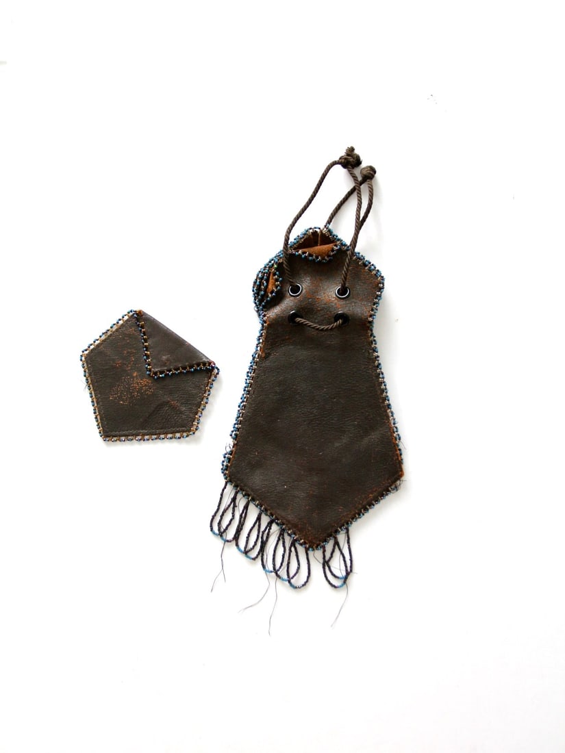 Antique Dark Brown Leather Drawstring Pouch with Beaded Trim: Antique Dark Brown Leather Drawstring Pouch with Beaded Trim Discover this exquisite antique leather pouch, a unique addition to any collection. Crafted from dark brown leather, this drawstring handba