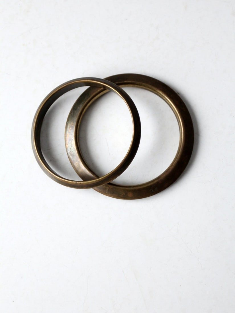 Charming Vintage Brass Bangles Set of 2 with Patina: Charming Vintage Brass Bangles Set of 2 with Patina This exquisite pair of vintage brass bangles showcases a beautiful tone and harmonious shapes, perfect for stacking. Each bracelet features a lovely