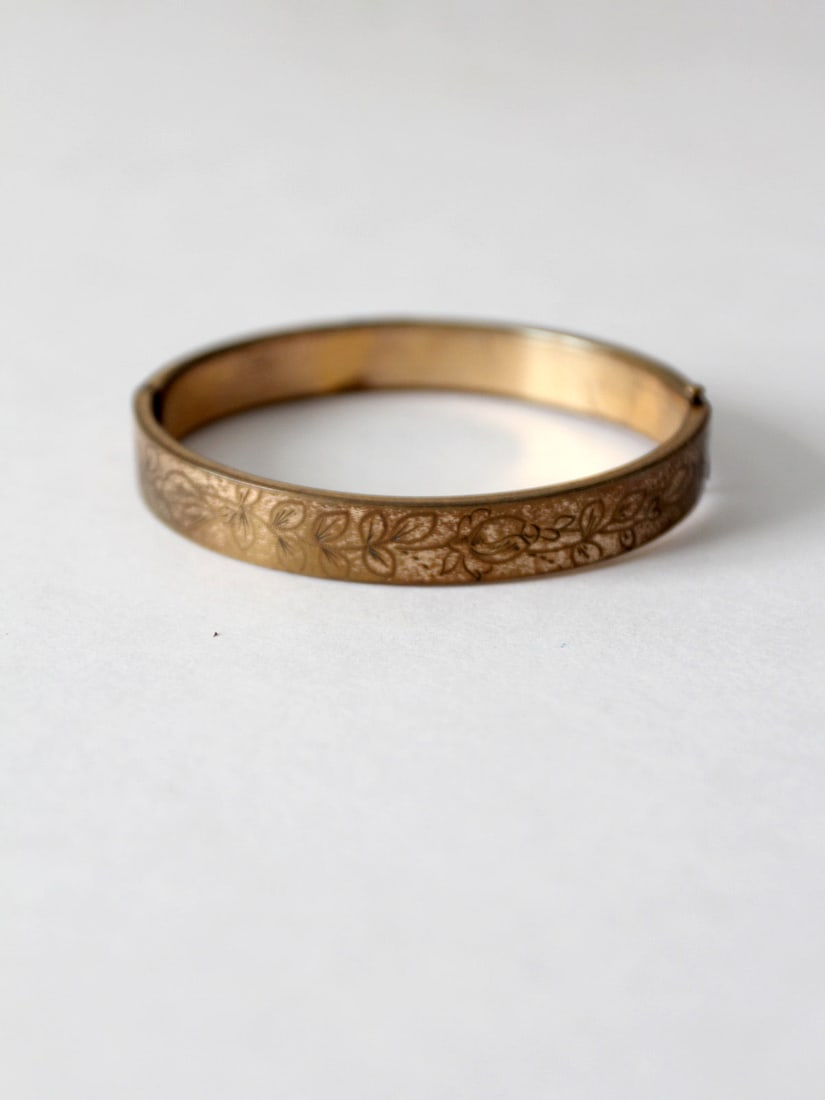 Vintage Gold Tone Floral Etched Bangle Bracelet: Vintage Gold Tone Floral Etched Bangle Bracelet Enhance your accessory collection with this vintage gold tone etched bangle bracelet. This elegant piece features a beautifully engraved floral design t