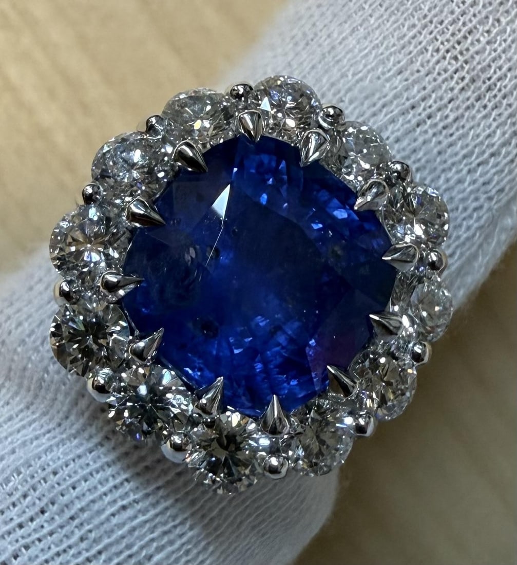 GIA Certified Platinum Ring With 11.74ct Cushion Color Change Sapphire and Diamond Halo: GIA Certified Platinum Ring With 11.74ct Cushion Color Change Sapphire and Diamond Halo This platinum cocktail ring showcases a certified natural Ceylon blue sapphire with a prominent color change fro