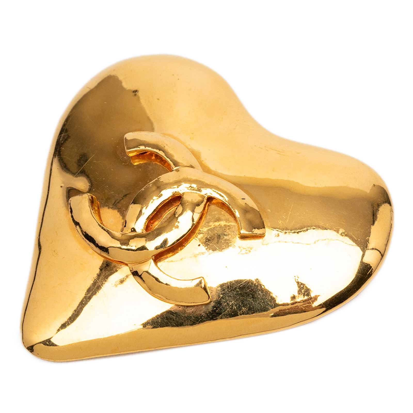 Chanel gold plated heart CC brooch: Chanel gold plated heart CC brooch This Chanel CC Gold Plated Heart Brooch is crafted from gold-tone metal and features a heart-shaped design with the iconic CC motif. The brooch is equipped with a ba