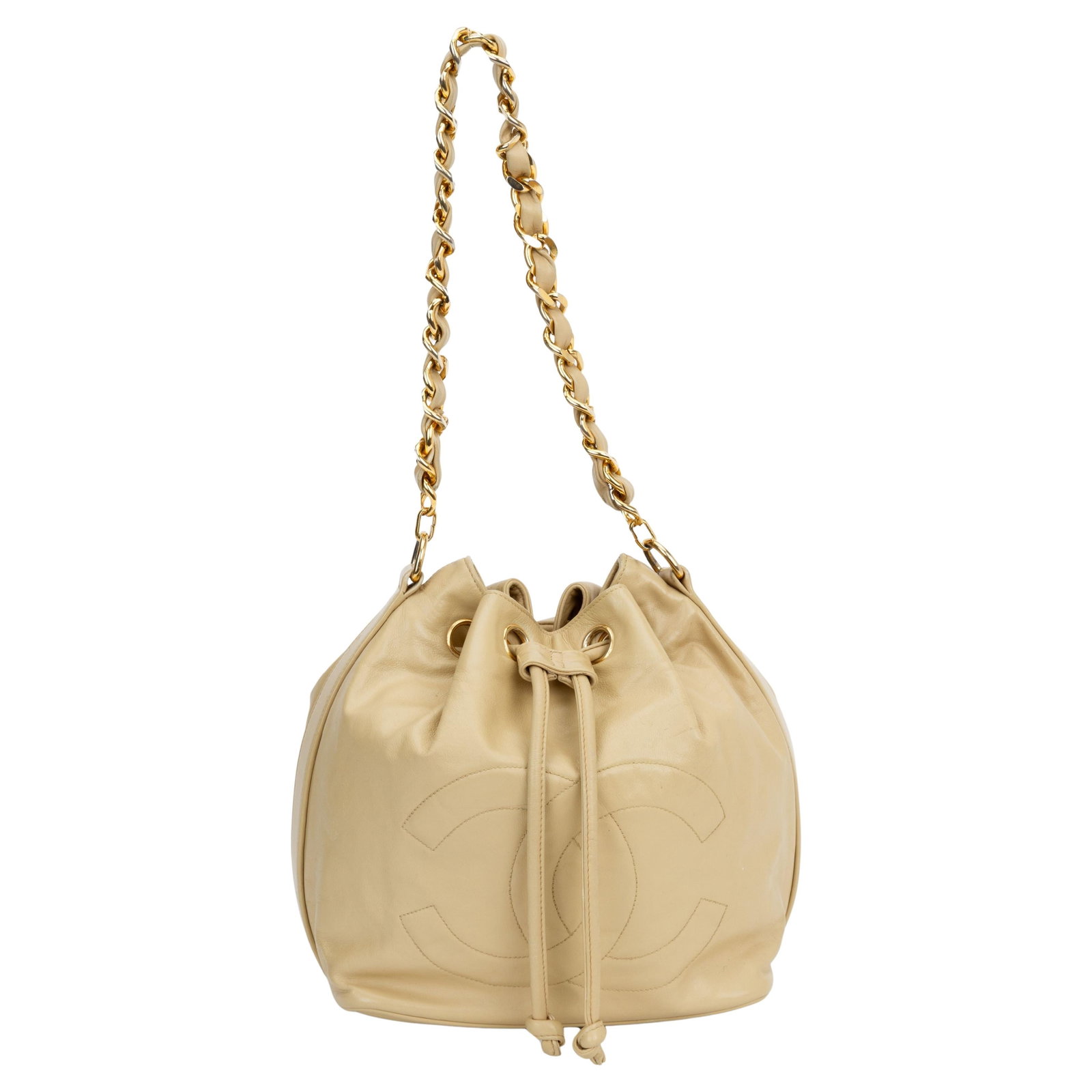 Chanel Beige Lambskin Bucket Bag with Drawstring Closure: Chanel Beige Lambskin Bucket Bag with Drawstring Closure This Chanel Beige Lambskin Drawstring Bucket Bag is crafted from high-quality leather and features a practical drawstring closure. The exterior