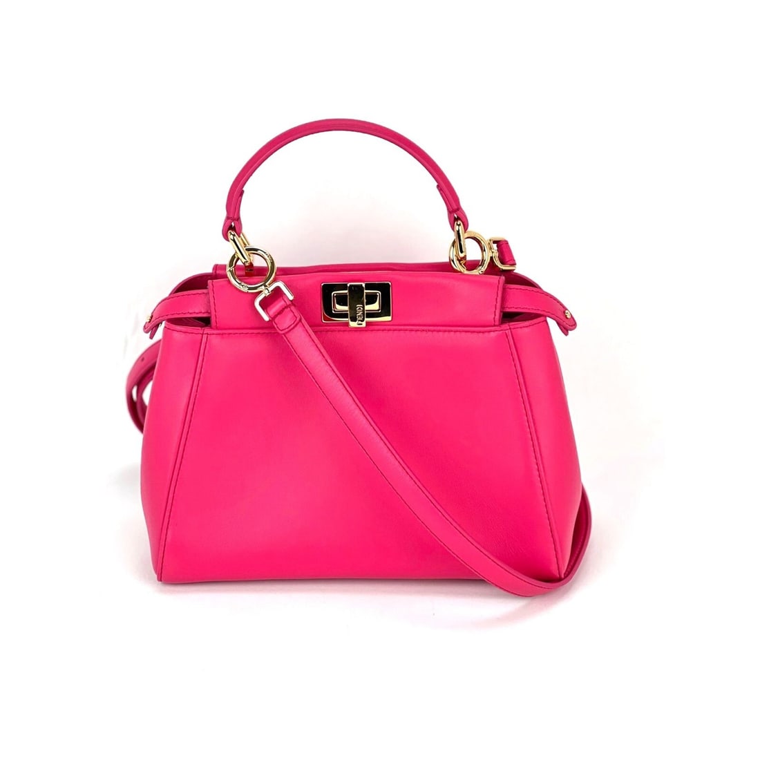 Fendi Mini Peekaboo Pink Leather Shoulder Bag with Gold Hardware: Fendi Mini Peekaboo Pink Leather Shoulder Bag with Gold Hardware Introducing the Fendi Mini Peekaboo, a stunning pink leather shoulder bag that embodies elegance and style. With a trapezoidal shape, t