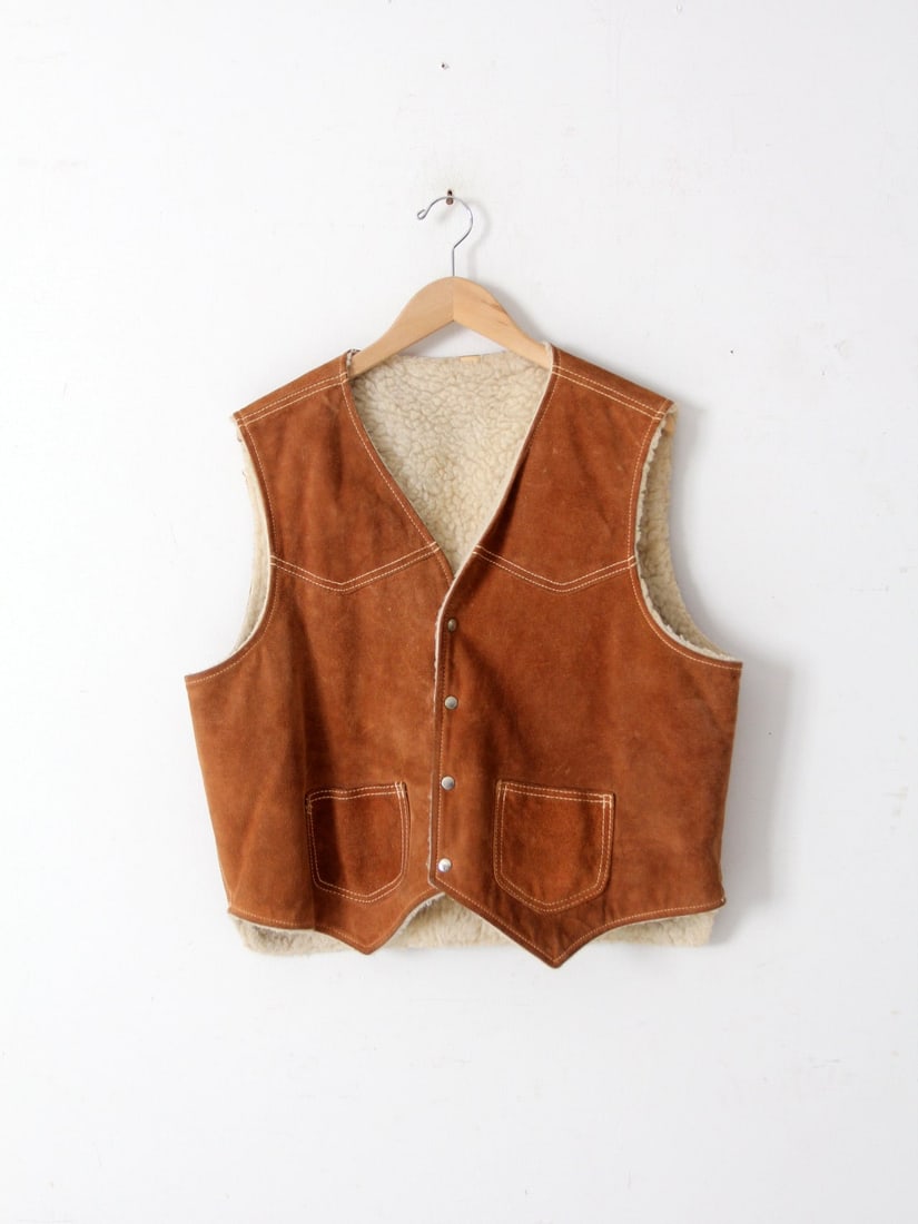 Retro 70s Suede Vest with Cozy Wool Lining and Pockets: Retro 70s Suede Vest with Cozy Wool Lining and Pockets This vintage 70s suede vest combines rugged practicality with comfort, featuring a cozy wooly lining that keeps you warm during cooler weather. I