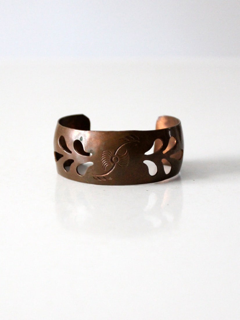 Wide Copper Cuff Bracelet With Sculptural Openwork and Engraved Center: Wide Copper Cuff Bracelet With Sculptural Openwork and Engraved Center This vintage copper cuff bracelet features a wide band with a sculptural openwork design. The surface displays a warm, deep tone 