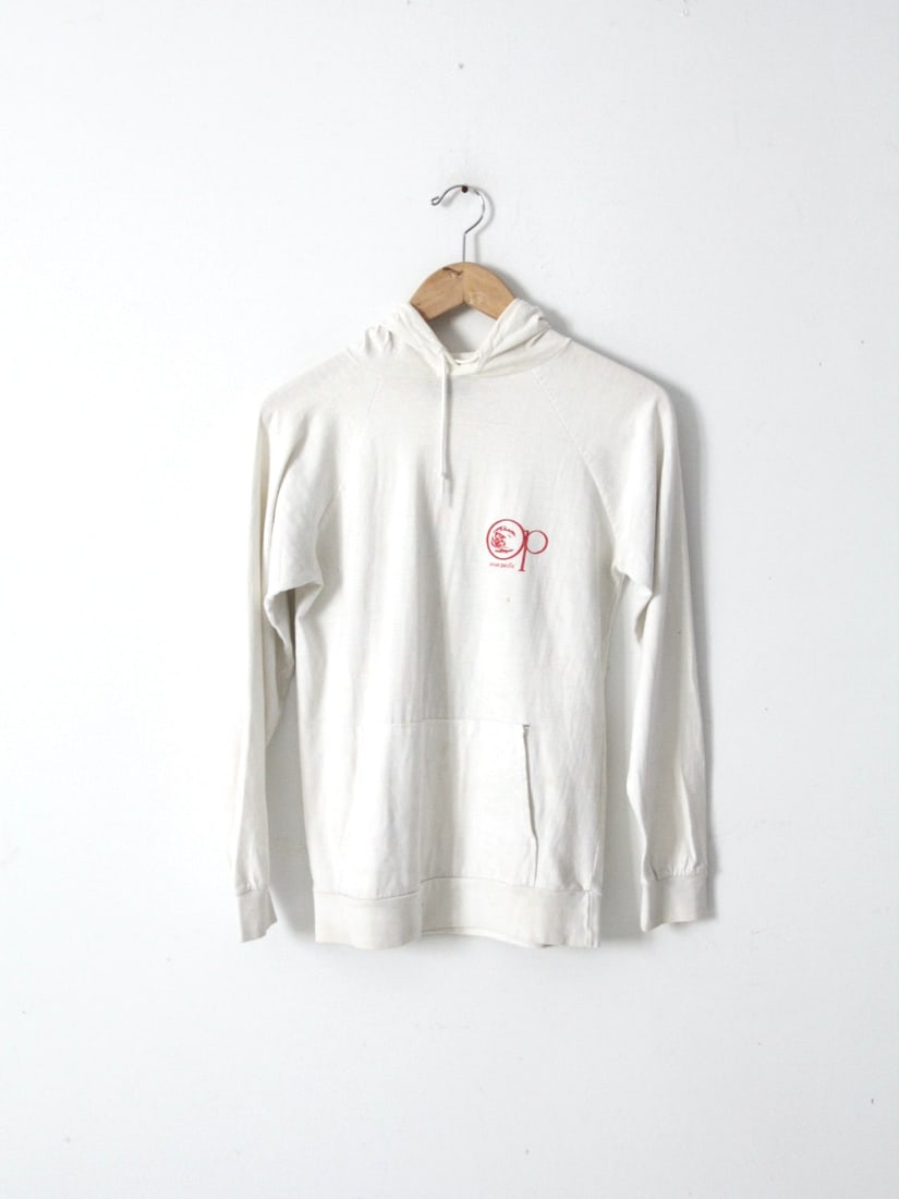 Retro 80s Ocean Pacific Long Sleeve T-Shirt with Pocket: Retro 80s Ocean Pacific Long Sleeve T-Shirt with Pocket This Vintage 80s Ocean Pacific t-shirt is a nostalgic piece from the 1980s. Made from 100% cotton, this long-sleeve hoodie tee features a conven