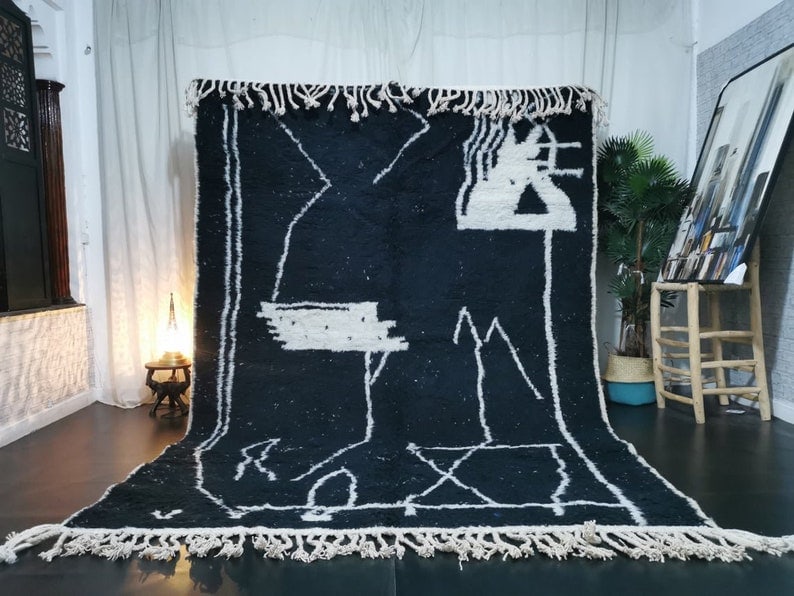 Handmade Moroccan Berber Wool Rug Black 9.84 x 6.56 Feet: Handmade Moroccan Berber Wool Rug Black 9.84 x 6.56 Feet Add a touch of elegance to your home with this Beautiful Soft Black Handmade Moroccan Berber Wool Rug. Featuring a unique white design and intr