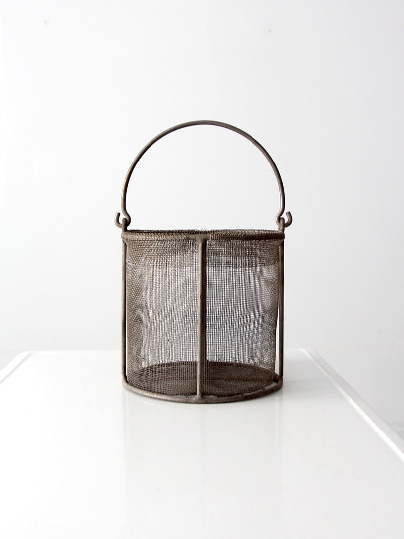 Early 20th Century Metal Wire Mesh Basket with Bail Handle: Early 20th Century Metal Wire Mesh Basket with Bail Handle This vintage wire mesh basket from the early to mid 20th century features a bail handle and a timeworn patina, reflecting decades of use. Its