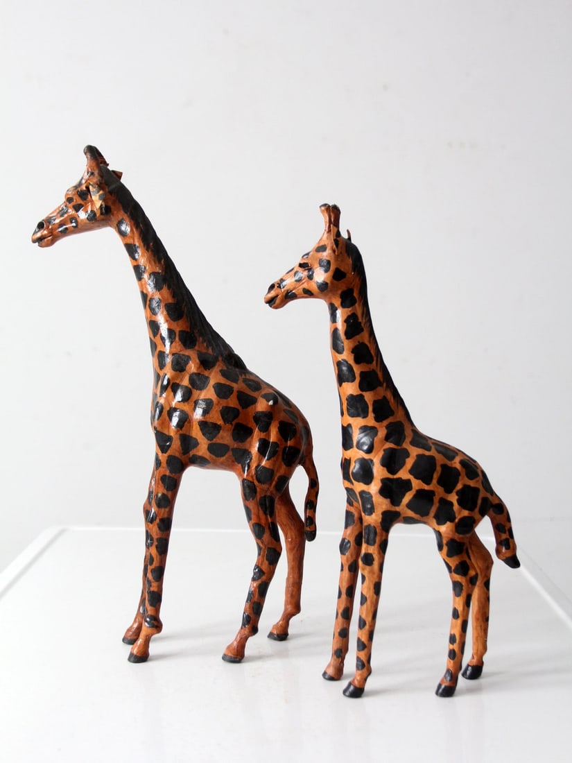 Vintage Mid-Century Leather Giraffe Sculptures Pair: Vintage Mid-Century Leather Giraffe Sculptures Pair This exquisite pair of vintage hand-formed leather giraffes showcases a captivating blend of artistic design and natural elegance. Each figure featu