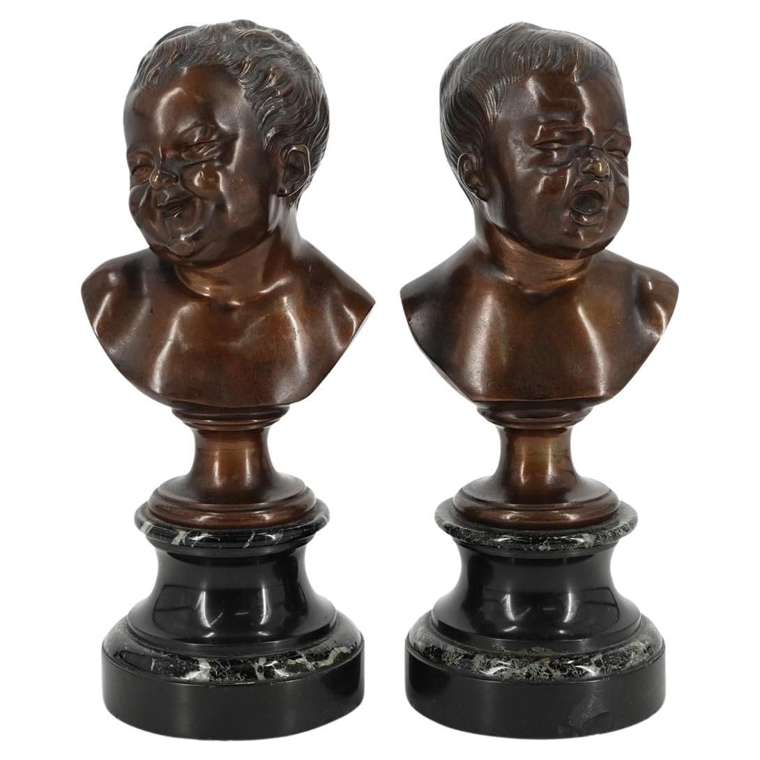 Set of Two French Bronze Infant Busts Inspired by Houdon: Set of Two French Bronze Infant Busts Inspired by Houdon Pair of late 19th-century French busts depicting laughing and crying infants, crafted in patinated bronze after the original models by Jean-Ant