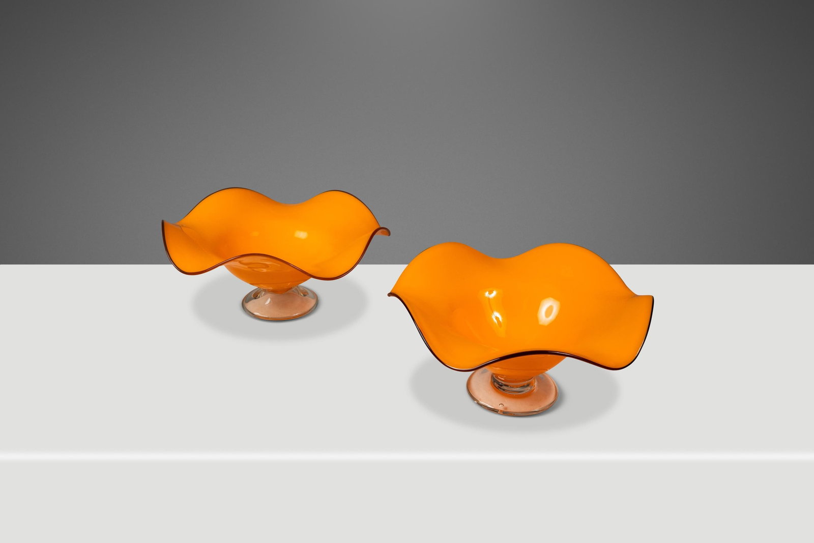 Mid-Century Teleflora Blown Art Glass Bowls Set in Orange & Clear: Mid-Century Teleflora Blown Art Glass Bowls Set in Orange & Clear This stunning set of two Teleflora blown art glass serving bowls, crafted in the USA during the 1970s, embodies the vibrant spirit of 