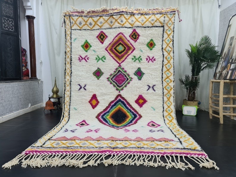 Vibrant Handmade Moroccan Berber Wool Area Rug 8 x 5 Feet: Vibrant Handmade Moroccan Berber Wool Area Rug 8 x 5 Feet Enhance your space with this stunning handmade Moroccan Berber wool area rug. Featuring a vibrant and colorful design with hues of pink, yello