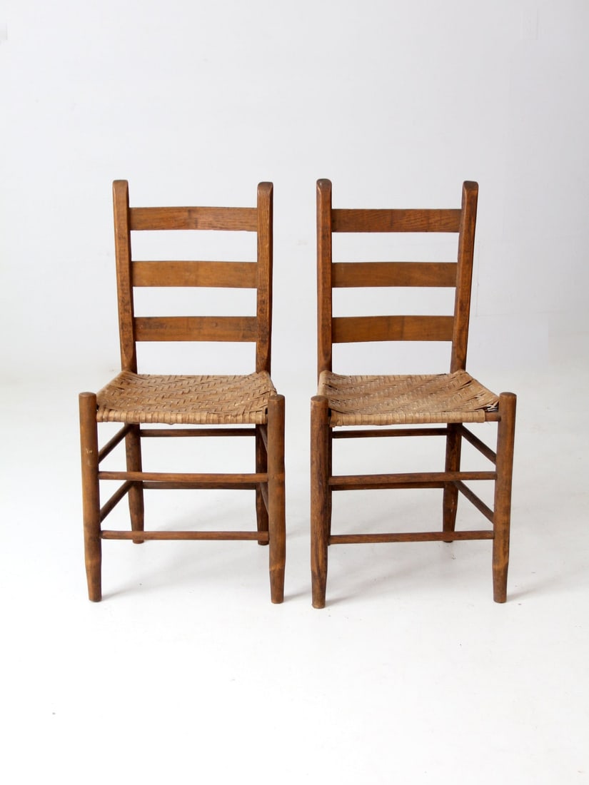 Rustic Antique Splint Weave Chairs Pair with Ladder Backs: Rustic Antique Splint Weave Chairs Pair with Ladder Backs This exquisite pair of antique splint weave seat chairs embodies rustic charm with their sturdy wooden construction. Each chair features a cla