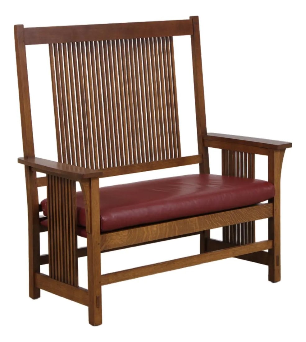 Stickley oak spindle back settee with burgundy leather cushion: Stickley oak spindle back settee with burgundy leather cushion A Stickley Mission oak leather spindle settee from circa 1994, featuring an Arts & Crafts oak spindle back, mortise and tenon constructio
