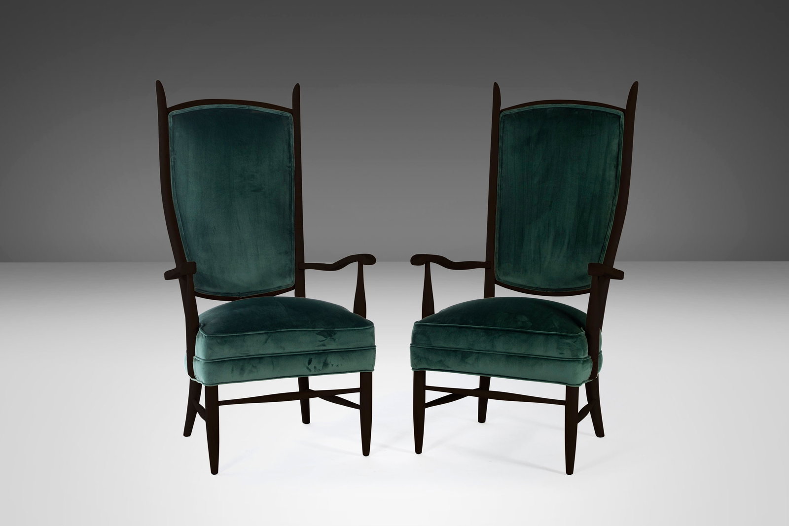 Pair of 1950s Maxwell Royal High Back Upholstered Chairs in Forest Green Velvet: Pair of 1950s Maxwell Royal High Back Upholstered Chairs in Forest Green Velvet This exquisite set of two high back upholstered chairs showcases a striking ebonized wood finish with tapered horn-shape