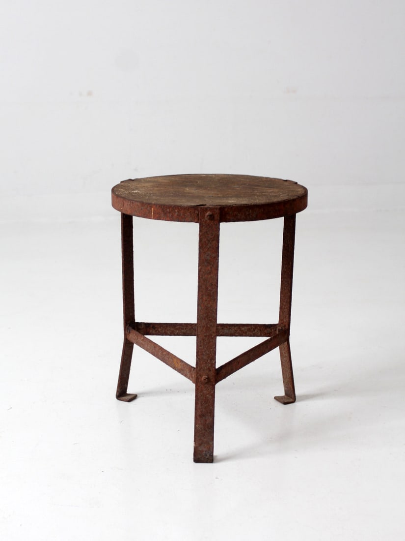 Vintage Industrial Three-Legged Stool with Wooden Seat: Vintage Industrial Three-Legged Stool with Wooden Seat This vintage industrial stool features a unique three-legged design with a round wooden seat, complemented by a metal frame finished in aged red 