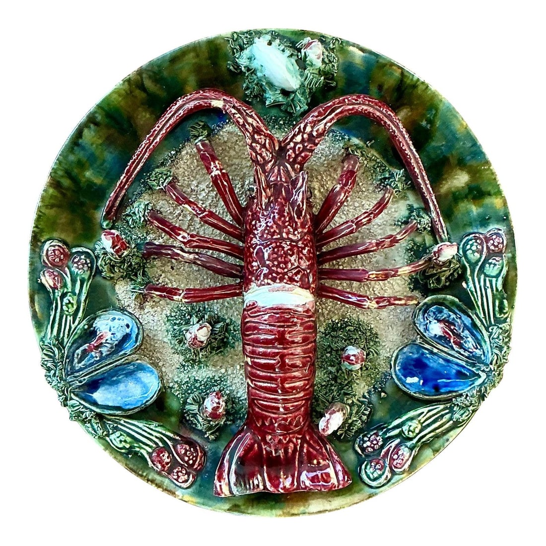 Palissy Style Majolica Plate with High Relief Lobster and Shell Motif: Palissy Style Majolica Plate with High Relief Lobster and Shell Motif This vintage French majolica plate showcases a striking high-relief depiction of a spiny lobster or crayfish in vivid crimson, set
