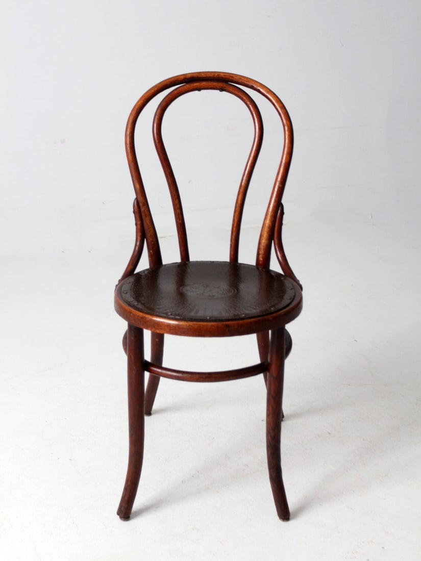 Classic Thonet Style Antique Bentwood Chair with Leather Seat: Classic Thonet Style Antique Bentwood Chair with Leather Seat This antique bentwood chair showcases the classic Thonet style with its elegantly curved wood frame and a luxurious, textured pressed leat