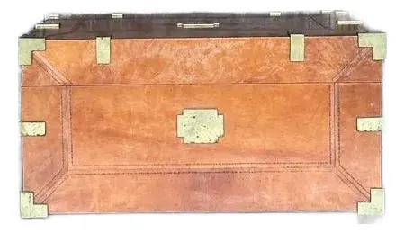 Vintage Cognac Leather Campaign Trunk with Brass Accents: Vintage Cognac Leather Campaign Trunk with Brass Accents Discover a vintage treasure with this elegant leather-wrapped campaign trunk, embodying a spirit of adventure and refined heritage. Wrapped in 