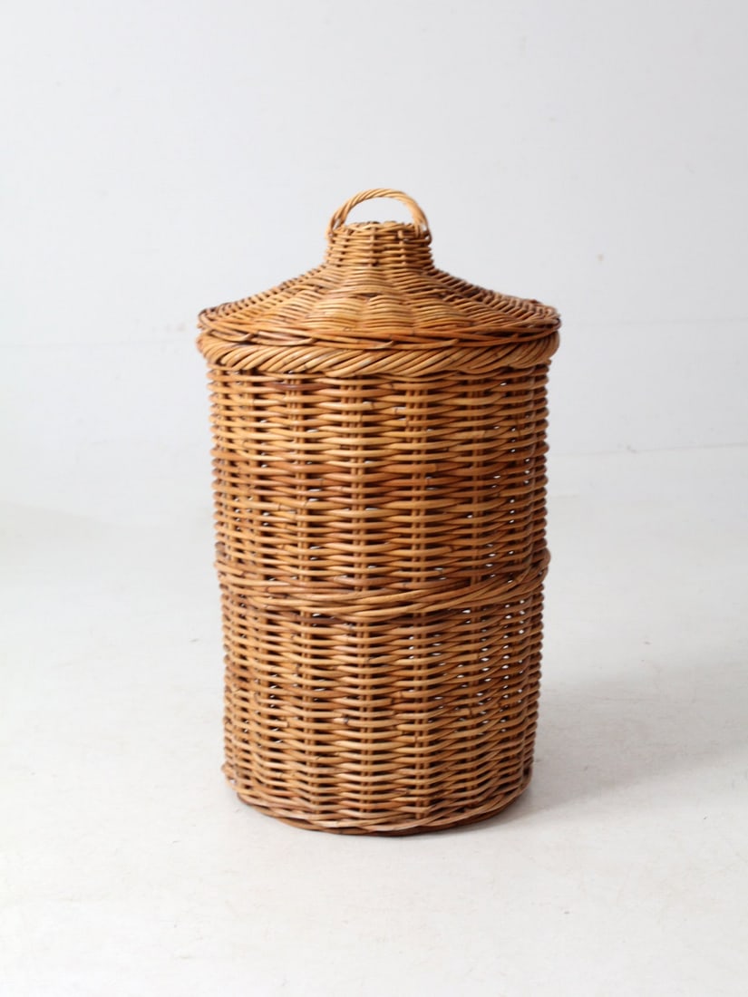 1970s Vintage Rattan Hamper Basket with Loop Handle: 1970s Vintage Rattan Hamper Basket with Loop Handle This vintage 1970s rattan hamper showcases a robust cylindrical weave and a slightly conical lid, complete with a looped rattan handle. Ideal for la
