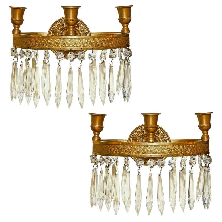 Set of 2 French Empire style gilt bronze wall sconces with crystal pendants: Set of 2 French Empire style gilt bronze wall sconces with crystal pendants A pair of antique French Empire style wall sconces in hoop form, made of gilt bronze with crystal pendants and three candle 