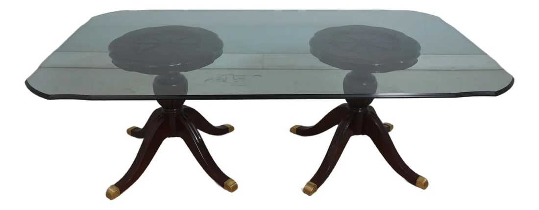 Mahogany Dining Table with Glass Top in Duncan Phyfe Style: Mahogany Dining Table with Glass Top in Duncan Phyfe Style This traditional dining room table features solid mahogany construction in the classic Duncan Phyfe style. The table has a shapely beveled gl