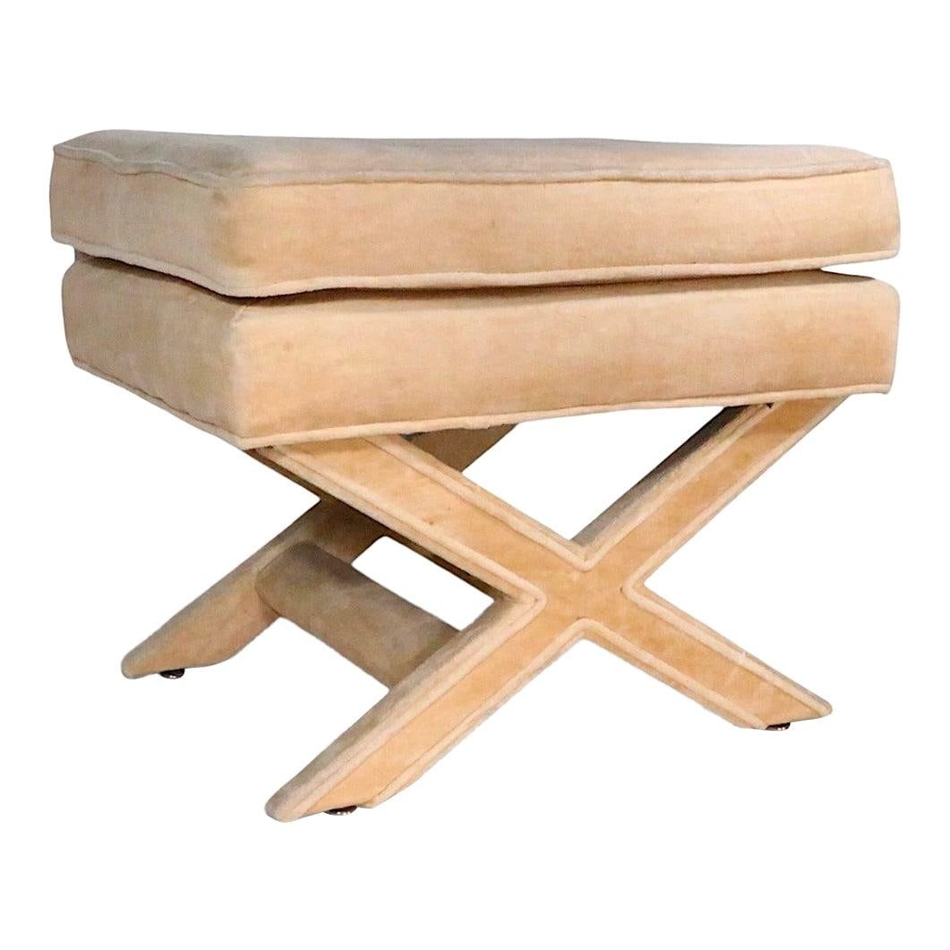 Vintage Tan Upholstered X Base Footstool Ottoman Bench Circa 1970s: Vintage Tan Upholstered X Base Footstool Ottoman Bench Circa 1970s This mid 20th century Hollywood Regency X-base upholstered ottoman features a stylish design reminiscent of the era, with a tan fabri