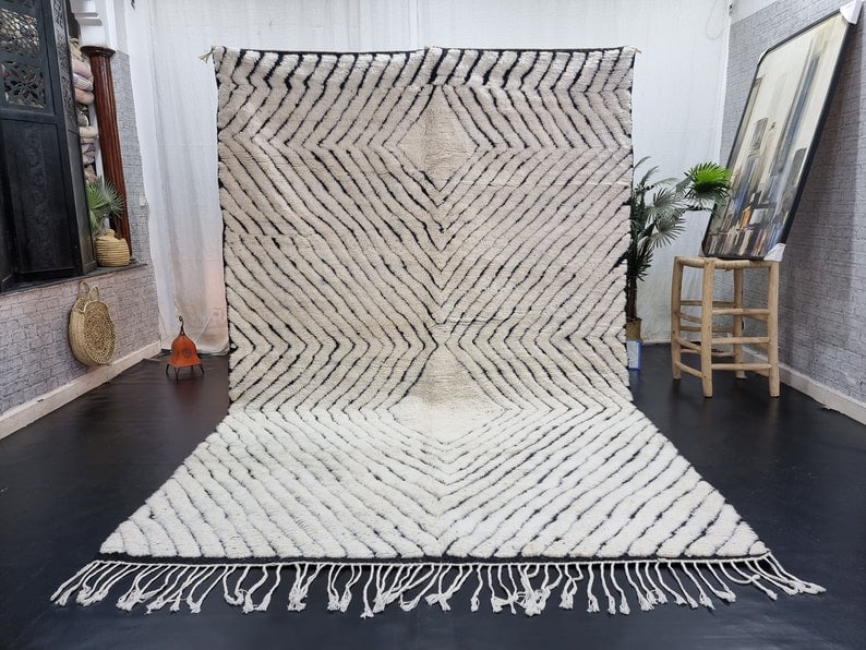 Handwoven Moroccan Berber Rug 100% Wool 9.84 x 6.56 Feet: Handwoven Moroccan Berber Rug 100% Wool 9.84 x 6.56 Feet Discover the elegance of this Stylish White Handwoven Moroccan Berber Rug, featuring a striking black engraved geometric pattern. Handwoven in 