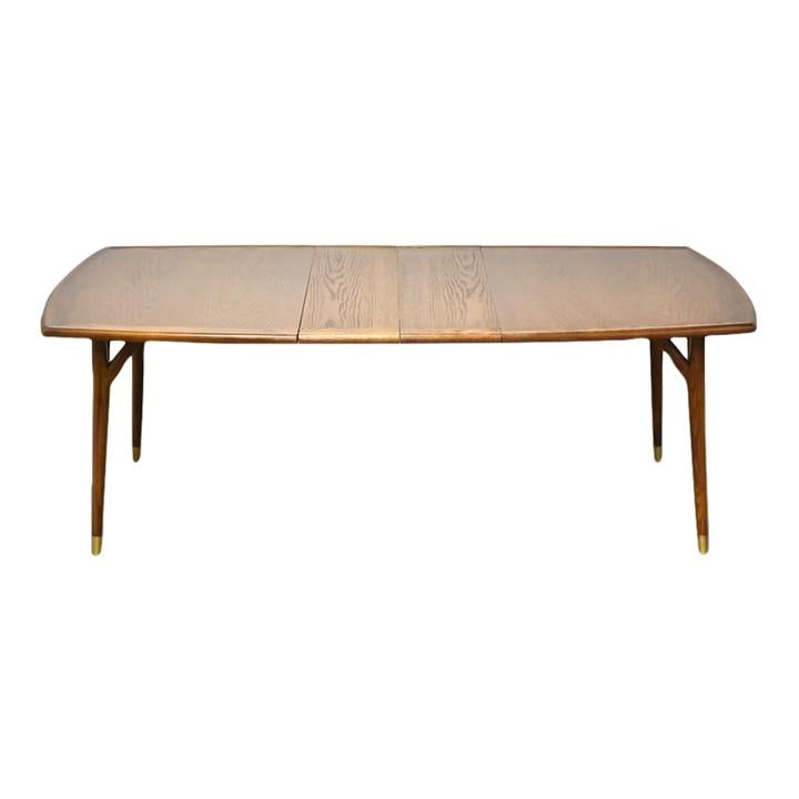 Mid Century Modern Chestnut Extendable Dining Table with Brass Ferrules: Mid Century Modern Chestnut Extendable Dining Table with Brass Ferrules This mid-century modern dining table is crafted from rich chestnut wood and features elegant brass ferrules. The table includes 