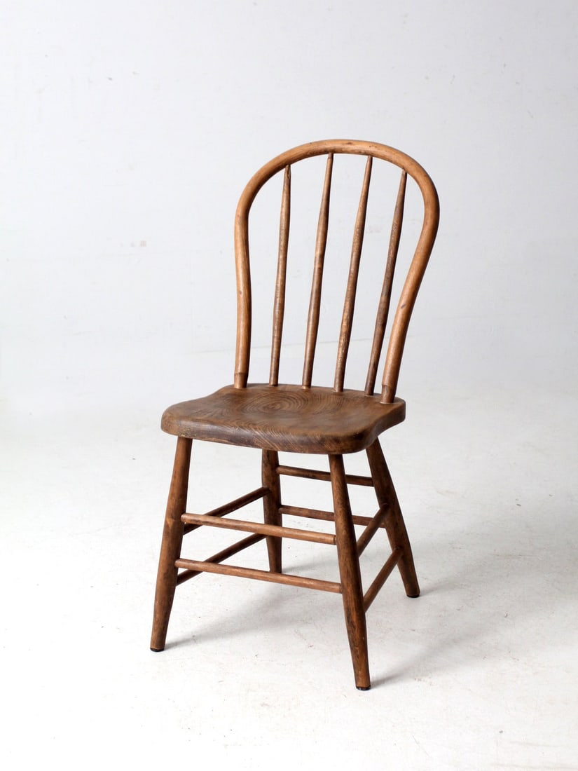 Vintage Antique Windsor Chair with Spindle Back Design: Vintage Antique Windsor Chair with Spindle Back Design Add a touch of timeless farmhouse charm to your space with this antique Windsor chair. It features a rounded spindle back and a sculpted saddle s