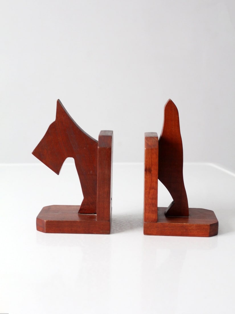 Pair of Mid-Century Folk Art Style Wooden Dog Bookends: Pair of Mid-Century Folk Art Style Wooden Dog Bookends This pair of mid-20th century bookends features stylized dog figures carved from wood, blending folk art sensibility with Art Deco-inspired lines