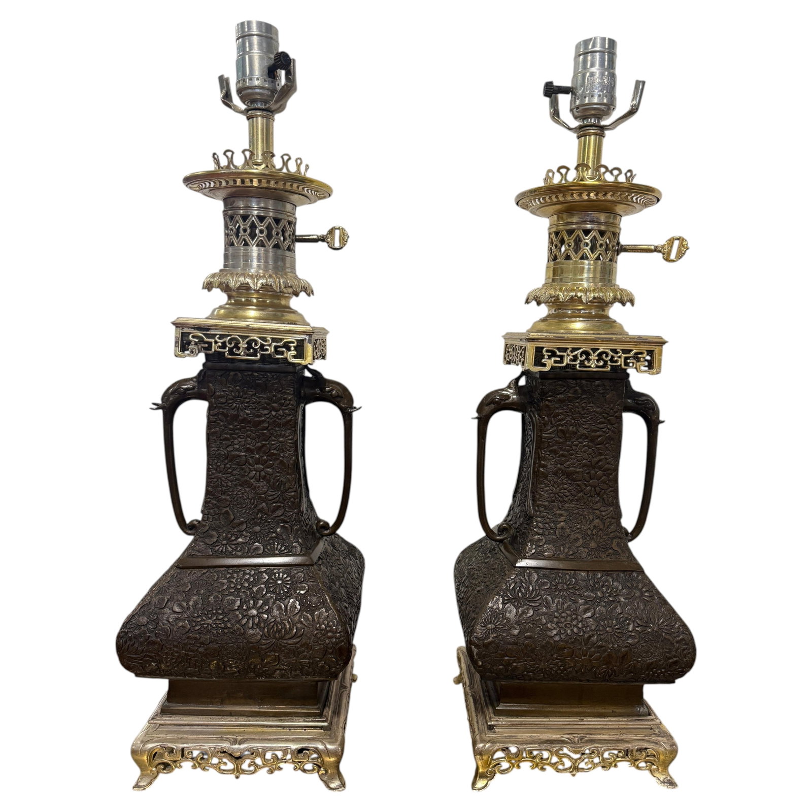 Set of Two East Asian Bronze Floral Relief Table Lamps with Elephant Handles: Set of Two East Asian Bronze Floral Relief Table Lamps with Elephant Handles This pair of table lamps showcases the Aesthetic Movement style with a strong East Asian influence, featuring substantial b