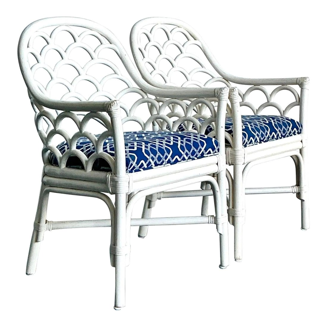 Pair of White Rattan Lounge Chairs with Scalloped Palm Beach Design: Pair of White Rattan Lounge Chairs with Scalloped Palm Beach Design This pair of vintage rattan lounge chairs features a distinctive scalloped back design inspired by coastal motifs, finished in crisp