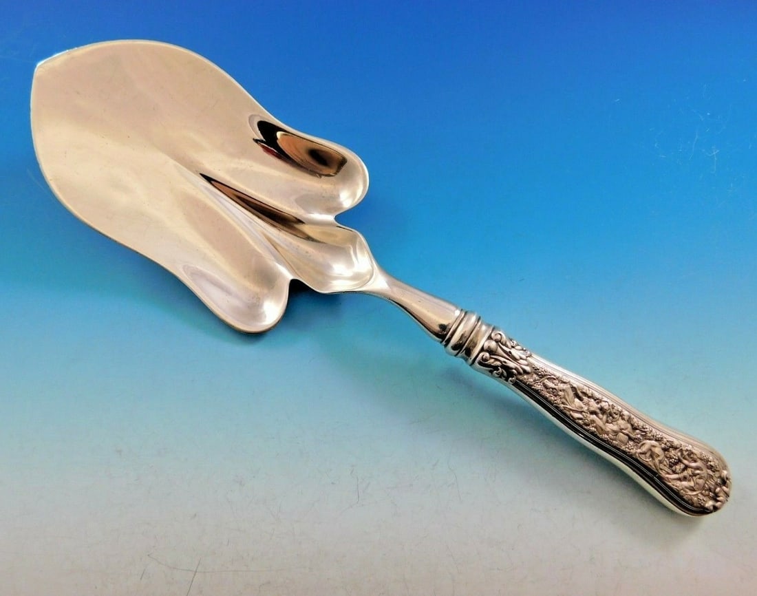 Tiffany & Co Olympian Sterling Silver Pastry Server 10 3/4" Bacchus Motif: Tiffany & Co Olympian Sterling Silver Pastry Server 10 3/4" Bacchus Motif This exquisite pastry server from Tiffany & Co. features the iconic Olympian pattern, renowned for its intricate design that d