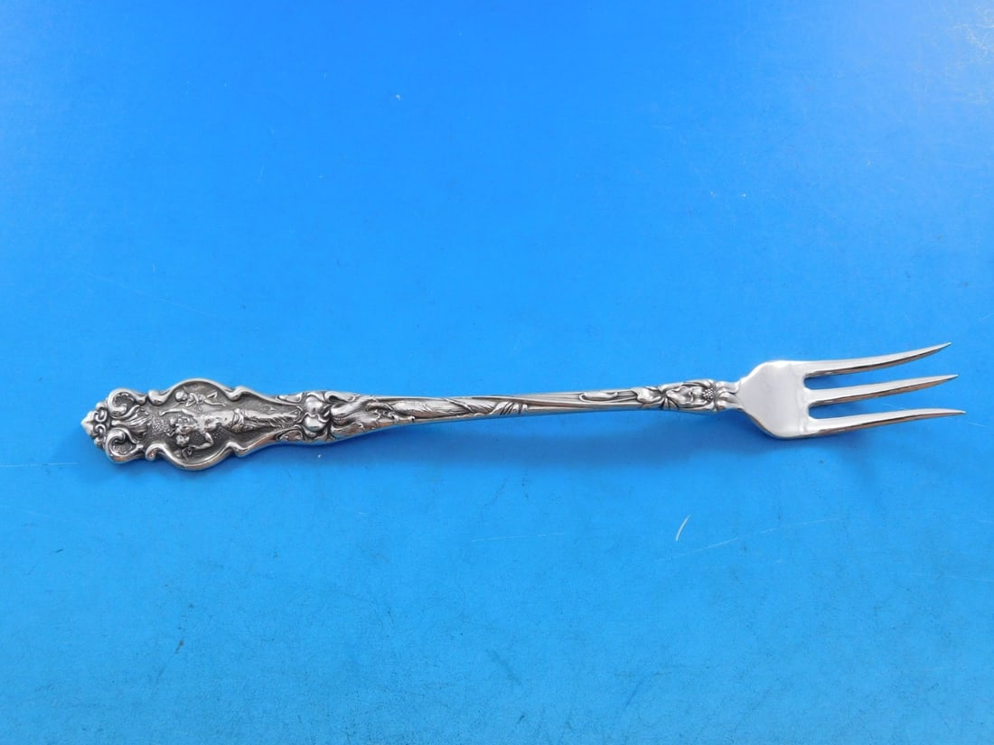 Wallace Irian Sterling Silver Cocktail Fork Art Nouveau 5 3/4": Wallace Irian Sterling Silver Cocktail Fork Art Nouveau 5 3/4" Elevate your dining experience with this exquisite Irian cocktail fork by Wallace, crafted from high-quality sterling silver. With a leng