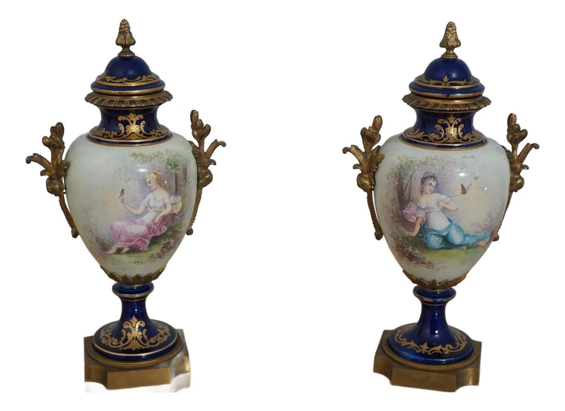 Vintage Sevres Blue and White Porcelain Lidded Urns with Bronze Trim: Vintage Sevres Blue and White Porcelain Lidded Urns with Bronze Trim This exquisite pair of vintage Sevres porcelain lidded urns showcases the elegance of 1930s French design. Each urn features beauti