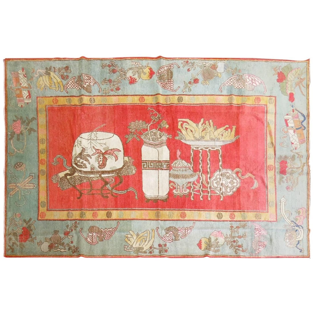 Early 20th Century Khotan Wool Hand-Woven Watermelon Vase Rug: Early 20th Century Khotan Wool Hand-Woven Watermelon Vase Rug This early 20th century Khotan rug from East Turkestan showcases a striking watermelon-colored field complemented by a green border, embod