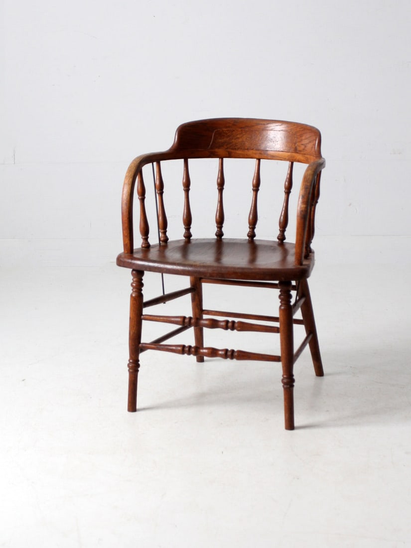 Vintage Wooden Barrel-Back Captain's Chair in Chestnut Finish: Vintage Wooden Barrel-Back Captain's Chair in Chestnut Finish This antique wooden captain's chair features a classic barrel-back design complemented by turned spindles and a solid plank seat. The chai