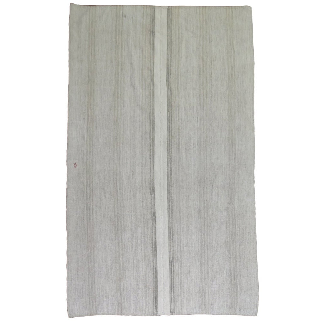 Mid Century Turkish Kilim Rug in Ivory Gray 78 x 129 in: Mid Century Turkish Kilim Rug in Ivory Gray 78 x 129 in This mid-century handmade Turkish Kilim features a minimalist design in shades of gray and ivory. Crafted circa 1950, it is woven from a blend o