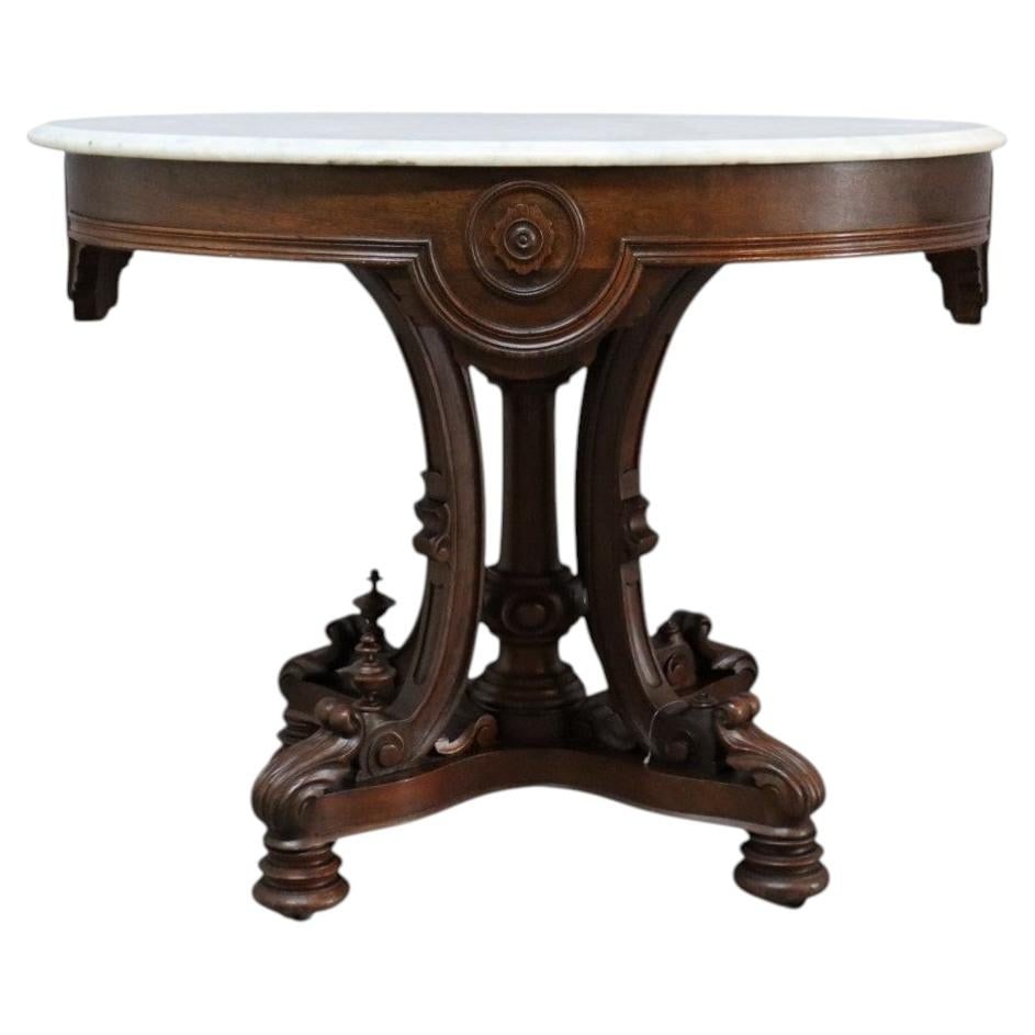 Oval marble top center table attributed to Berkey and Gay: Oval marble top center table attributed to Berkey and Gay An antique Berkey & Gay attributed Renaissance Revival center table with an elegant oval white marble top. The richly carved base features cla