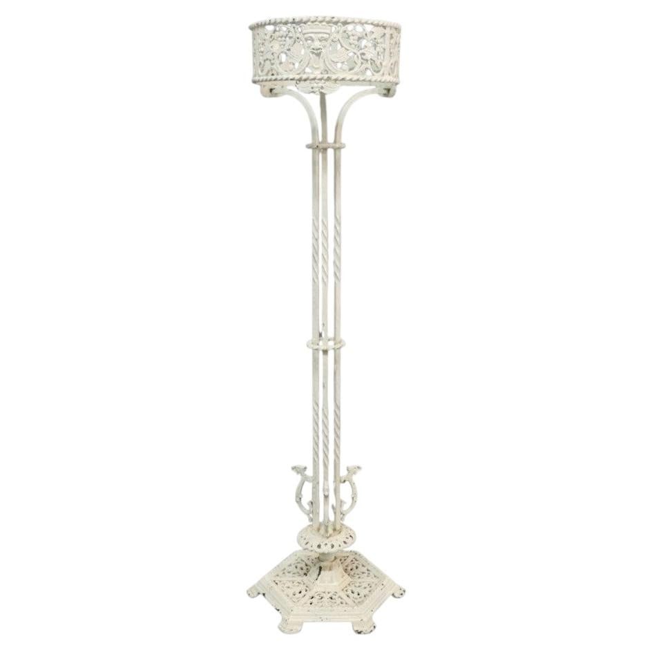 Oscar Bach bronze plant stand crowned mask grape leaf motif c1920: Oscar Bach bronze plant stand crowned mask grape leaf motif c1920 This antique plant stand, attributed to Oscar Bach and dating to around 1920, is crafted from bronze with an off-white painted finish.