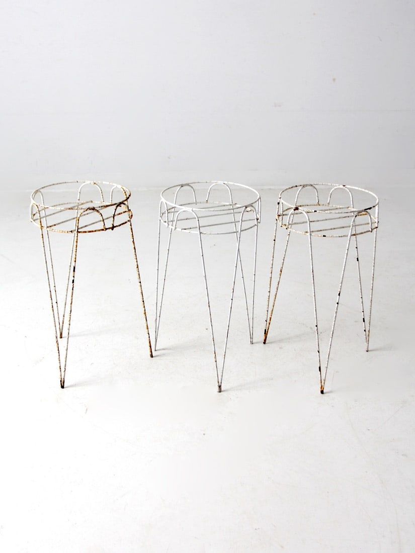 Set of 3 Vintage Hairpin Leg Plant Stands: Set of 3 Vintage Hairpin Leg Plant Stands Enhance your space with this charming set of three vintage hairpin leg plant stands. Crafted from metal, these stands feature a durable aged plasticized white