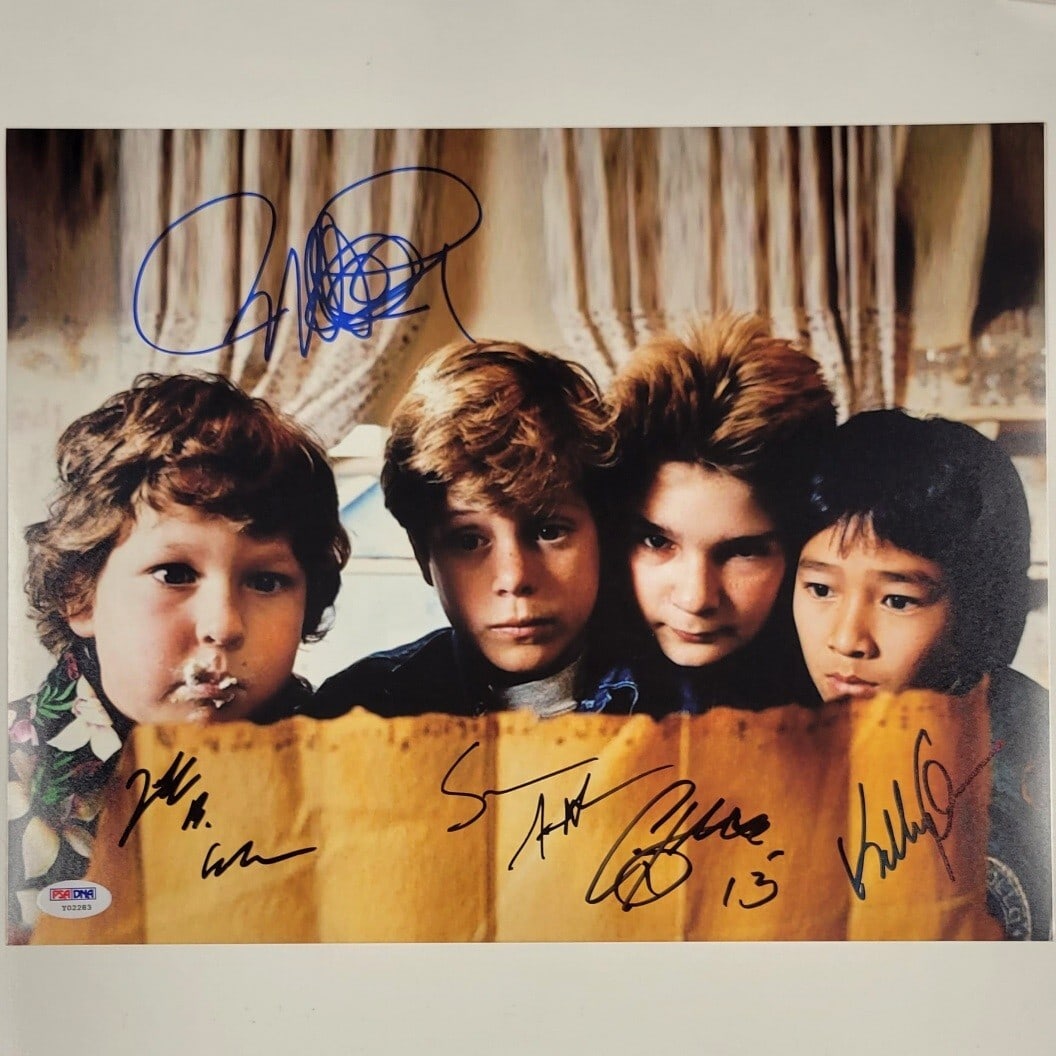 PSA DNA authenticated 11x14 Goonies cast signed photo: PSA DNA authenticated 11x14 Goonies cast signed photo This 11x14 photograph from the movie The Goonies is signed by members of the cast, including Richard Donner, Cohen, Astin, Quan, and Feldman. The 
