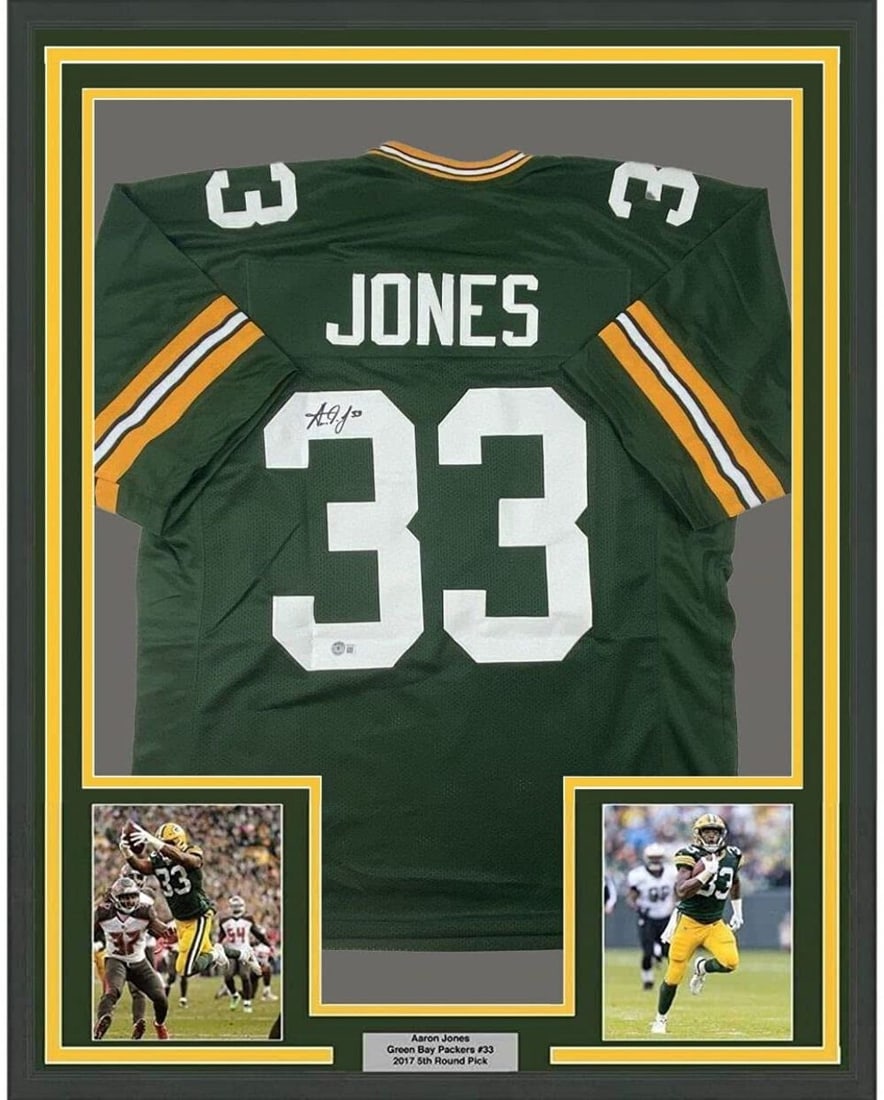 Aaron Jones Signed Green Bay Packers Framed NFL Jersey with BAS Authentication 33x42: Aaron Jones Signed Green Bay Packers Framed NFL Jersey with BAS Authentication 33x42 This framed Green Bay Packers football jersey features an authentic autograph by Aaron Jones. The jersey is profess
